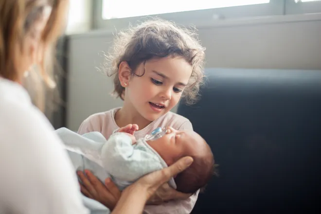 Le petit frère câline la petite sœur pendant son sommeil: c'est assez adorable